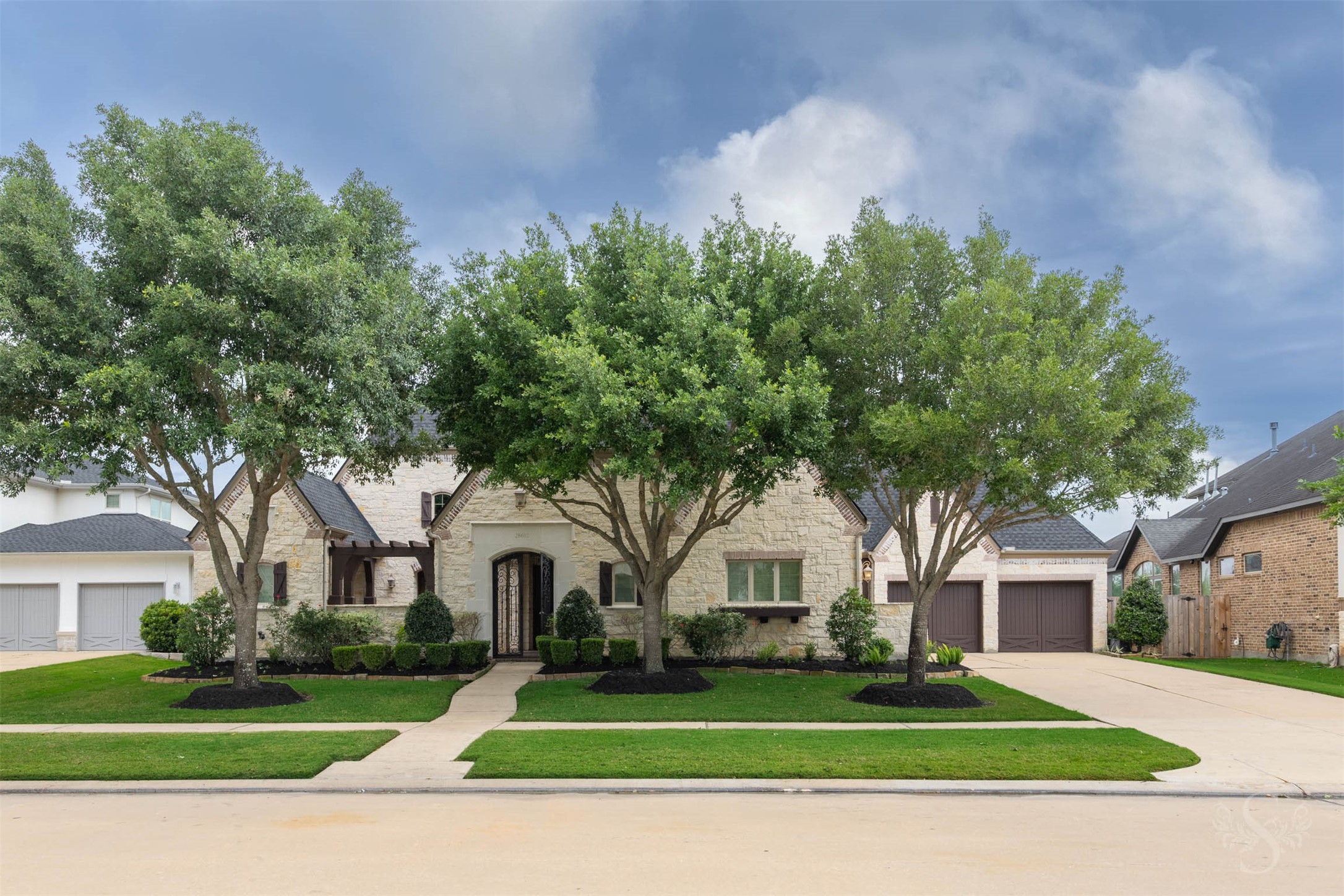 28602 Hoffman Spring Lane Fulshear, TX 77441 - Photo 49 of 49 Spectacular 2 story Huntington home set on an expansive greenbelt lot, offering 5,513 square feet, 5 bedrooms (2 down), 5 full and 3 half baths, and a rare 4-car garage. From the moment you arrive, the timeless stone façade, manicured landscape, and private courtyard entry create a striking first impression of the scale and architectural presence found throughout.