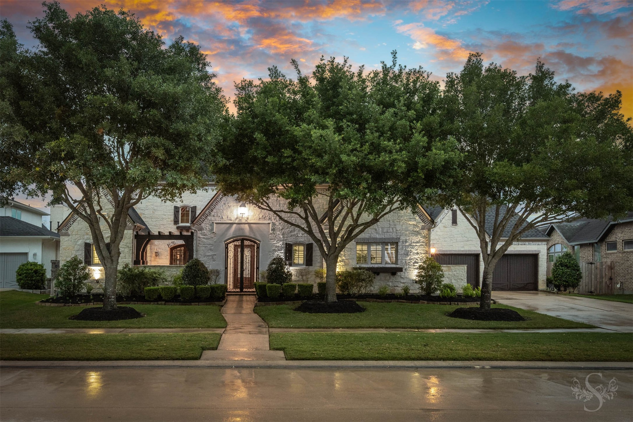 28602 Hoffman Spring Lane Fulshear, TX 77441 - Photo 5 of 49 Spectacular 2 story Huntington home set on an expansive greenbelt lot, offering 5,513 square feet, 5 bedrooms (2 down), 5 full and 3 half baths, and a rare 4-car garage. From the moment you arrive, the timeless stone façade, manicured landscape, and private courtyard entry create a striking first impression of the scale and architectural presence found throughout.
