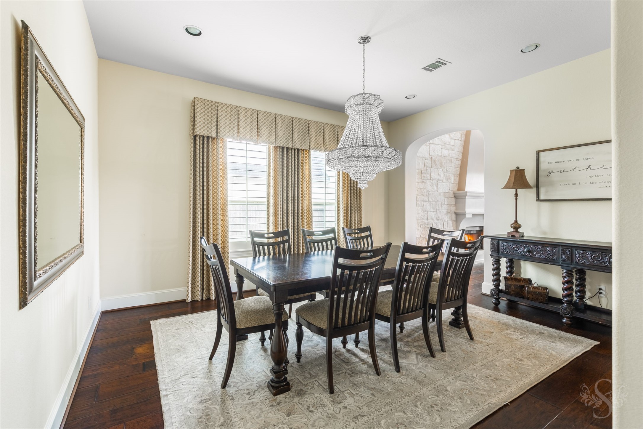 28602 Hoffman Spring Lane Fulshear, TX 77441 - Photo 9 of 49 Elegant formal dining room is perfectly positioned for entertaining, featuring a statement chandelier, generous proportions, and wood flooring that carries through the main living areas. Large windows with plantation shutters provide a polished backdrop while maintaining privacy for more intimate gatherings.