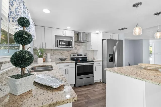 a kitchen with stainless steel appliances kitchen island a refrigerator and a sink