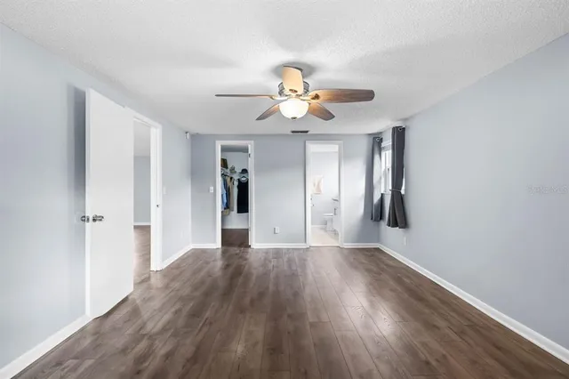 a view of a big room with wooden floor and a ceiling fan