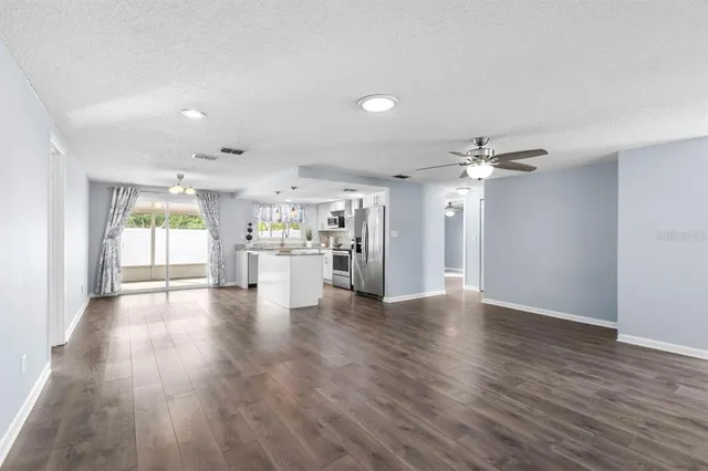 a view of empty room with wooden floor and window