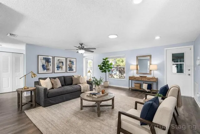 a living room with furniture wooden floor and a large window
