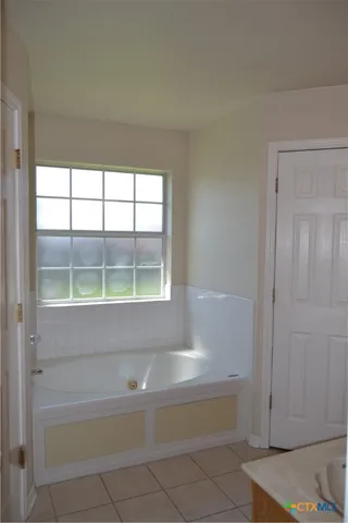 a bathroom with bathtub and window