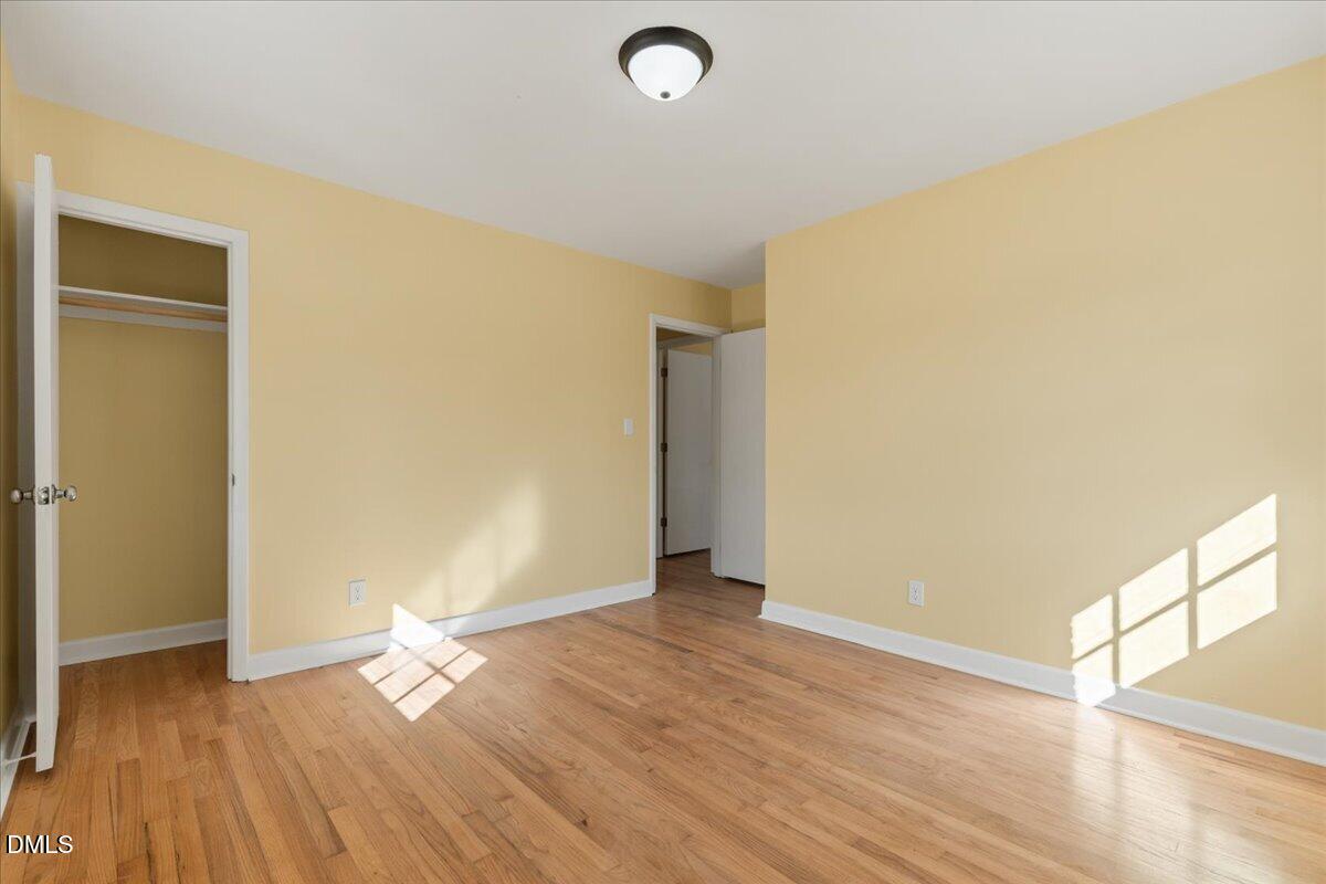 3620 Oates Drive Raleigh, NC 27604 - Photo 13 of 26 an empty room with wooden floor and windows