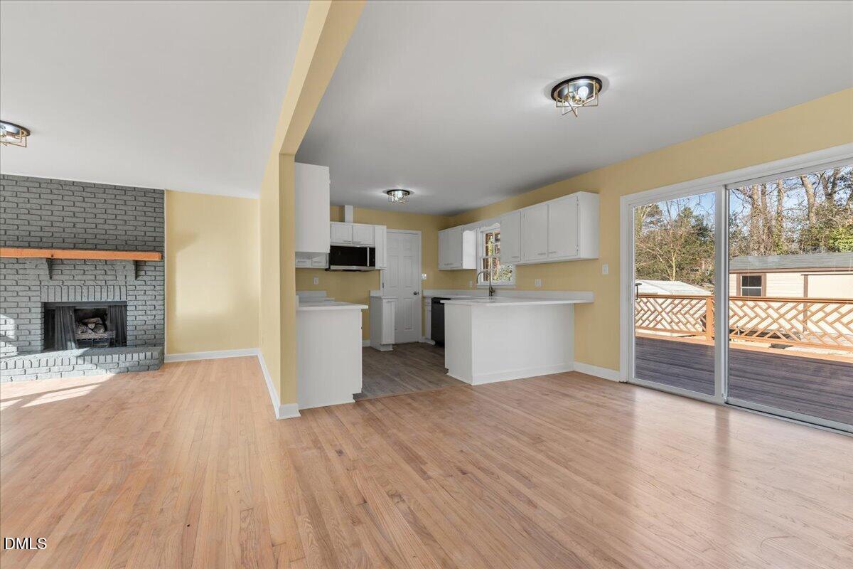 3620 Oates Drive Raleigh, NC 27604 - Photo 7 of 26 a view of a kitchen with wooden floor and a fireplace