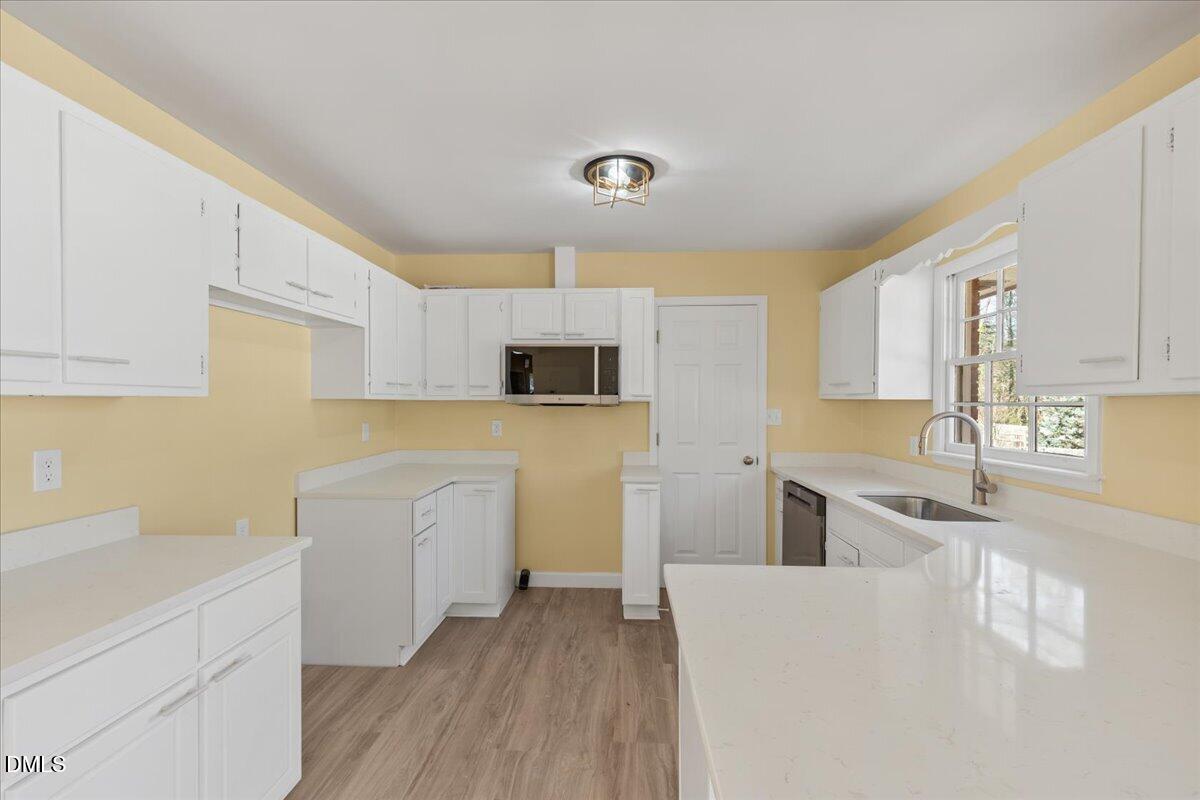 3620 Oates Drive Raleigh, NC 27604 - Photo 9 of 26 a kitchen with cabinets and wooden floor