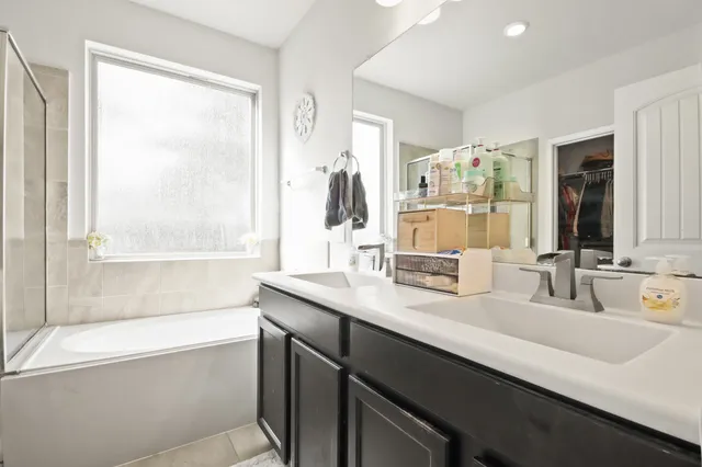 a bathroom with a double vanity sink and a bathtub