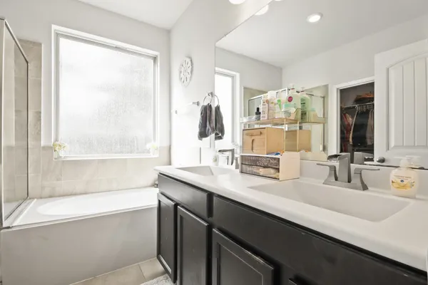 a bathroom with a double vanity sink and a bathtub