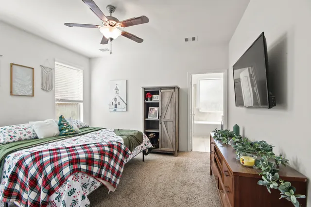 a bedroom with a bed window and a flat screen tv