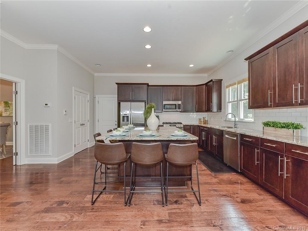 723 Harvest Pointe Drive Fort Mill, SC 29708 - Photo 18 of 47 a kitchen with a dining table chairs and wooden cabinets
