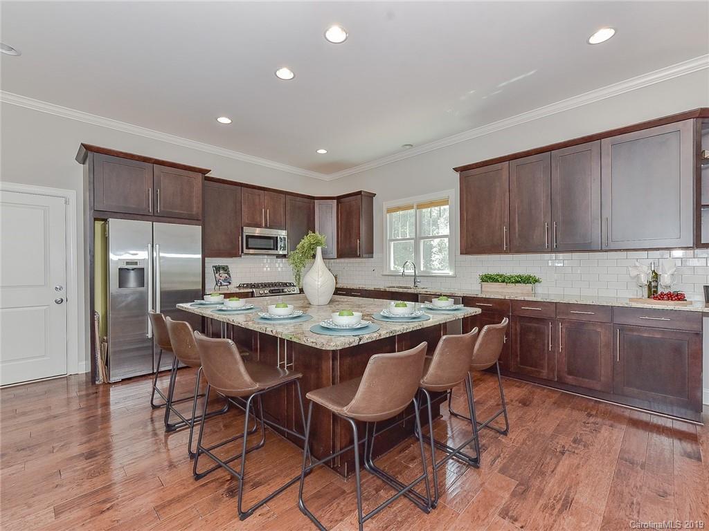 723 Harvest Pointe Drive Fort Mill, SC 29708 - Photo 19 of 47 a kitchen with granite countertop a table chairs stove microwave and cabinets