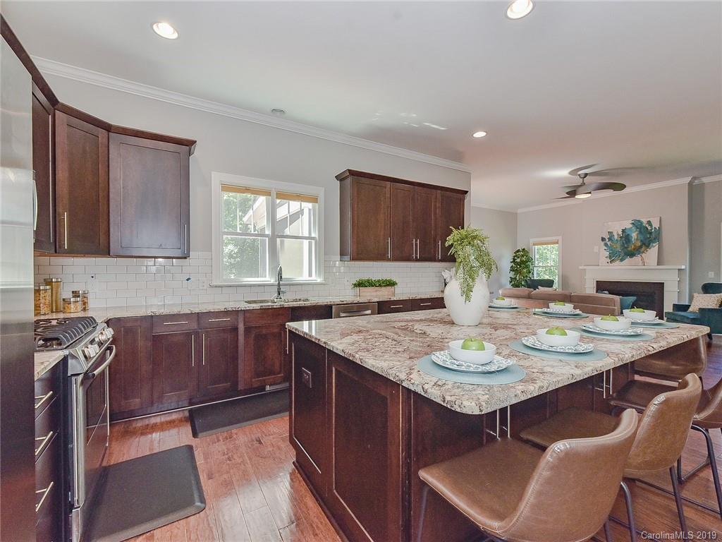 723 Harvest Pointe Drive Fort Mill, SC 29708 - Photo 20 of 47 a kitchen with a stove a sink a refrigerator and chairs