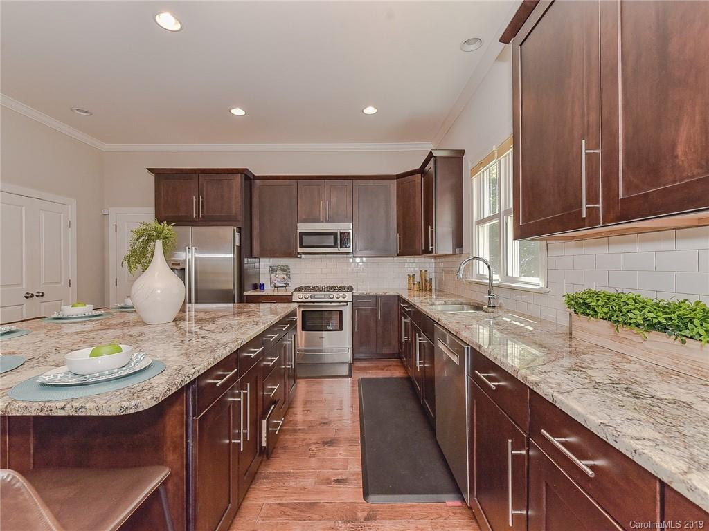 723 Harvest Pointe Drive Fort Mill, SC 29708 - Photo 21 of 47 a kitchen with kitchen island granite countertop a sink a stove and cabinets