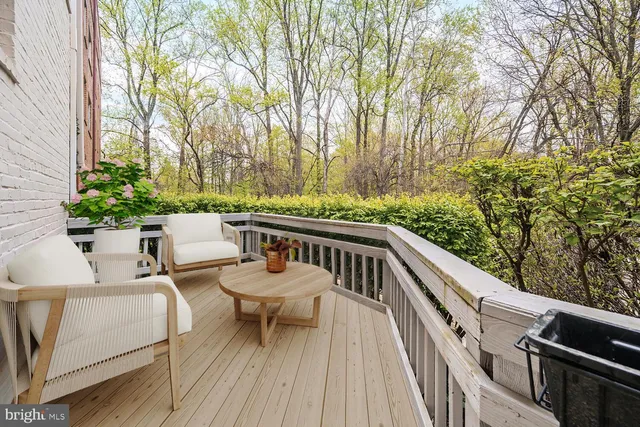 a balcony with wooden floor and outdoor seating
