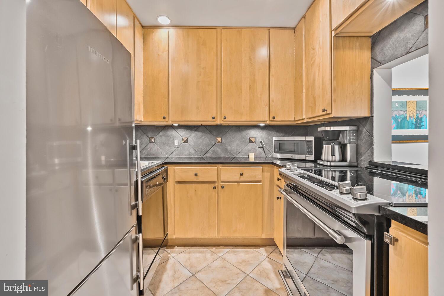 2212 Washington Avenue, Unit 102 Silver Spring, MD 20910 - Photo 3 of 27 a kitchen with stainless steel appliances granite countertop a stove a sink and a microwave