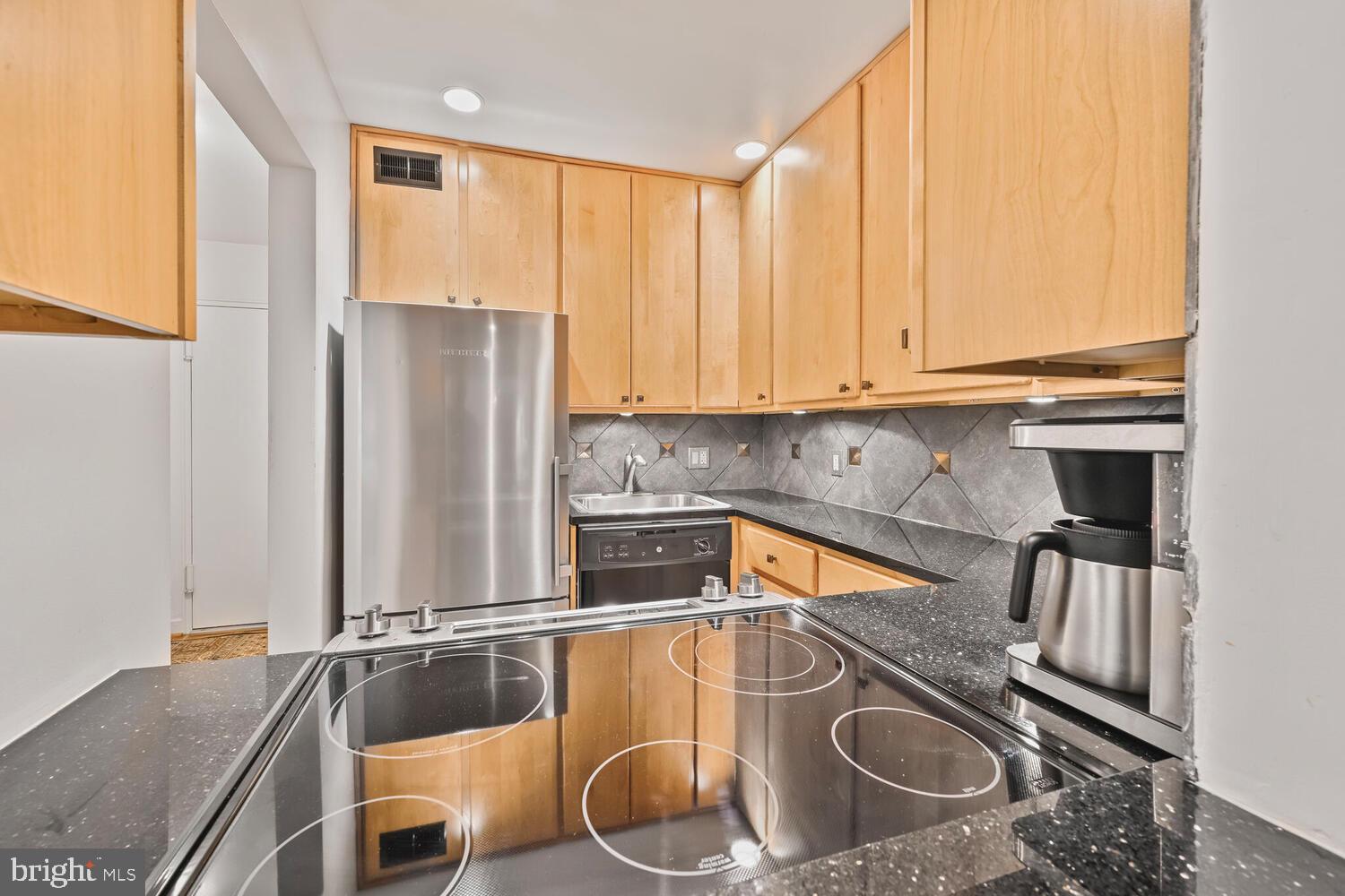 2212 Washington Avenue, Unit 102 Silver Spring, MD 20910 - Photo 5 of 27 a kitchen with stainless steel appliances granite countertop a sink stove and refrigerator
