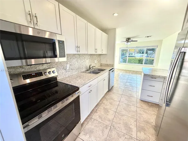 a kitchen with stainless steel appliances a stove a microwave and a sink