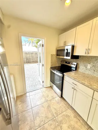 a kitchen with stainless steel appliances kitchen island granite countertop a sink and cabinets