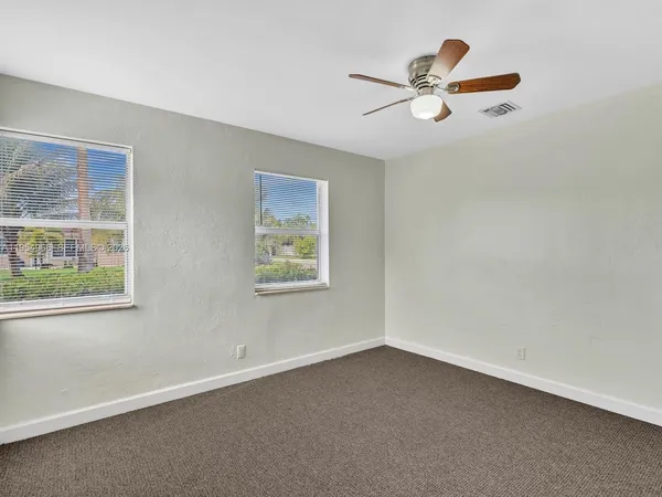 a view of a livingroom with a ceiling fan and window