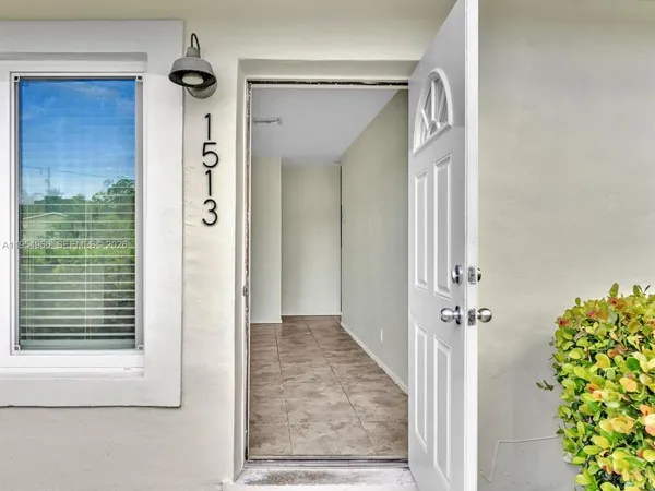 an entryway with a flower pot and a bookshelf