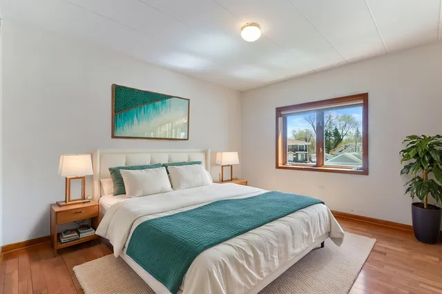 a bedroom with a bed and a painting on the wall