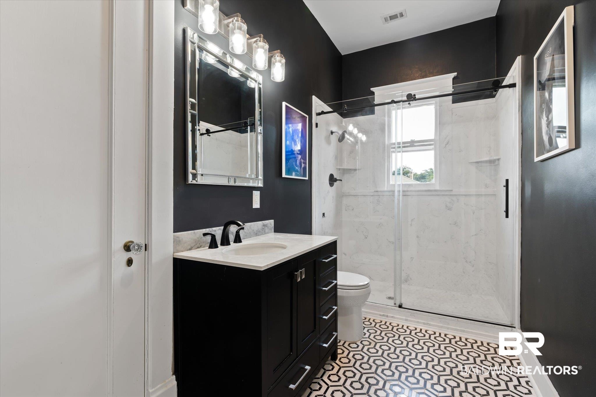 1953 Dauphin Street Mobile, AL 36606 - Photo 24 of 56 Bathroom featuring a shower with shower door, vanity, toilet, and tile patterned flooring
