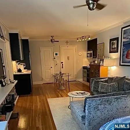 a living room with furniture a flat screen tv and kitchen view
