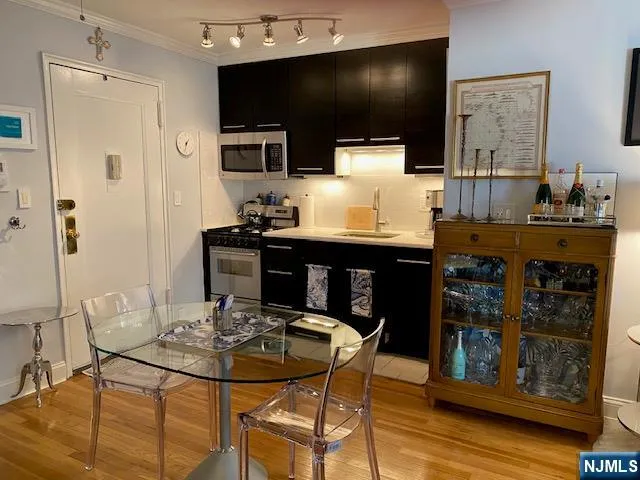 a kitchen with stainless steel appliances a dining table and chairs