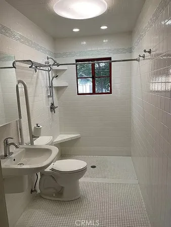 a bathroom with a sink toilet a mirror and shower