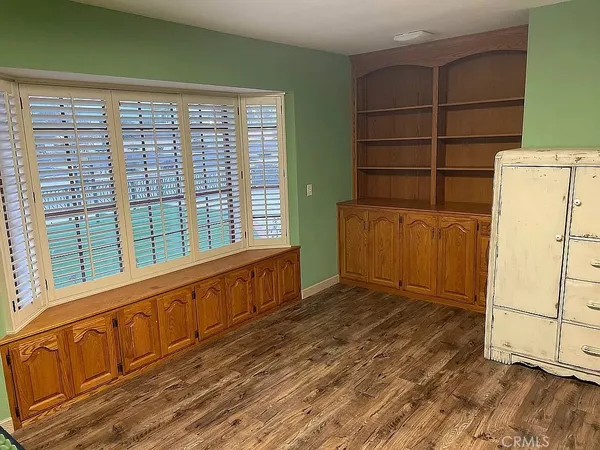 a view of a bedroom with wooden floor and cabinet