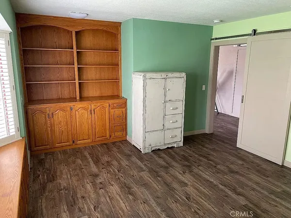 a view of a room with wooden floor and white walls