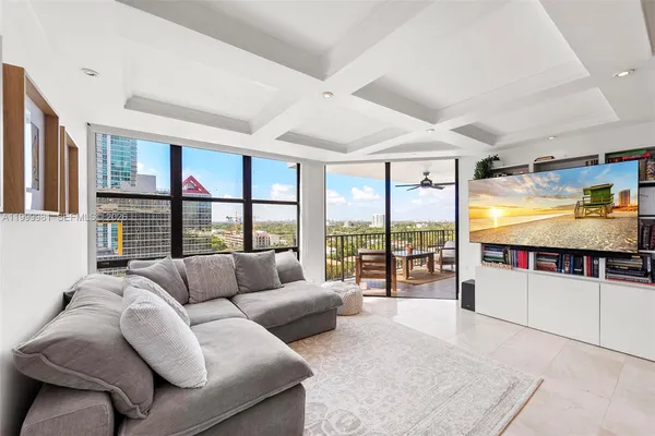 a living room with furniture tv and large window