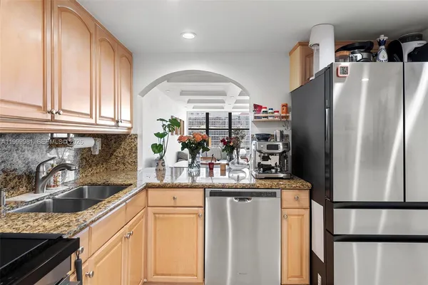 a kitchen with stainless steel appliances granite countertop a refrigerator and a sink