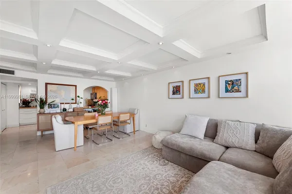 a living room with furniture and a dining table with chairs