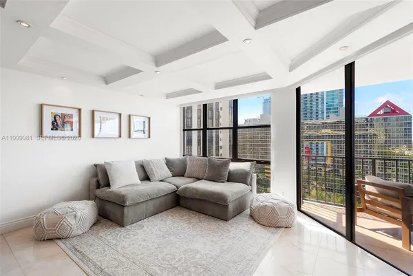a living room with furniture and a floor to ceiling window