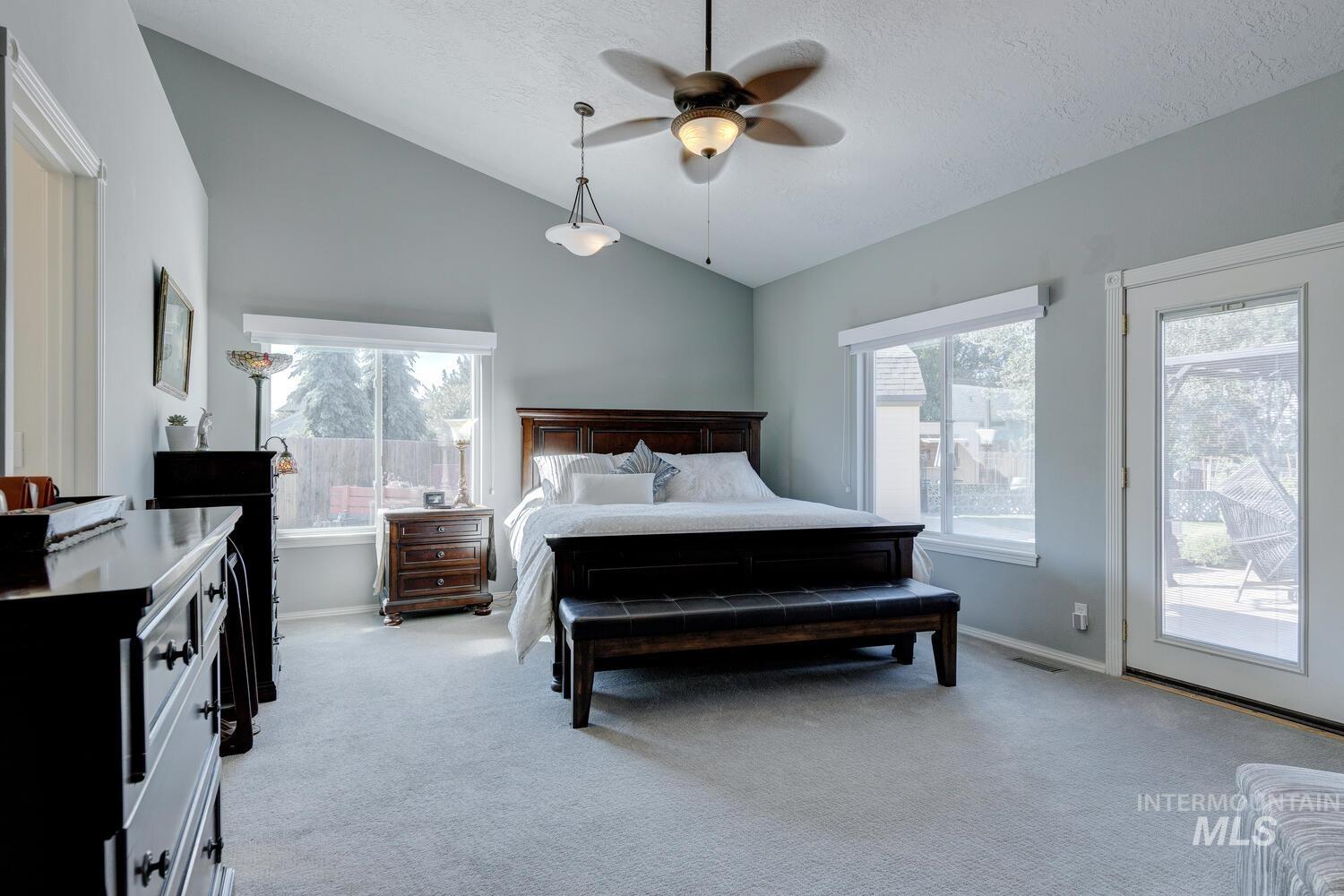10585 West Vega Court Star, ID 83669 - Photo 16 of 49 Bedroom featuring lofted ceiling, light carpet, access to exterior, ceiling fan, and a textured ceiling