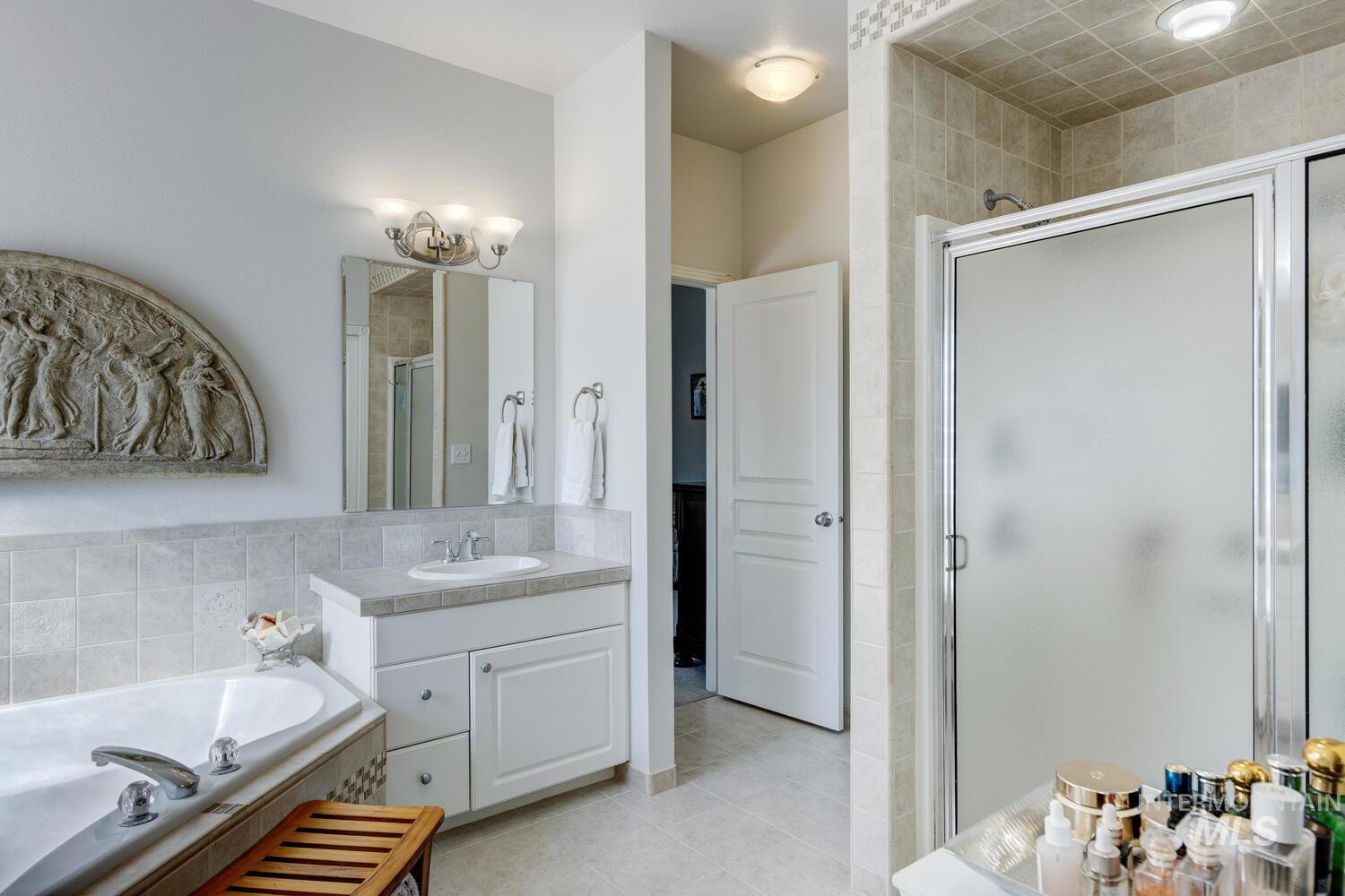 10585 West Vega Court Star, ID 83669 - Photo 20 of 49 Bathroom with a bath, vanity, a stall shower, and light tile patterned floors