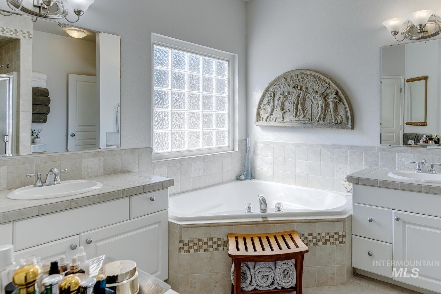 10585 West Vega Court Star, ID 83669 - Photo 21 of 49 Full bathroom featuring a chandelier, two vanities, a bath, and a shower stall