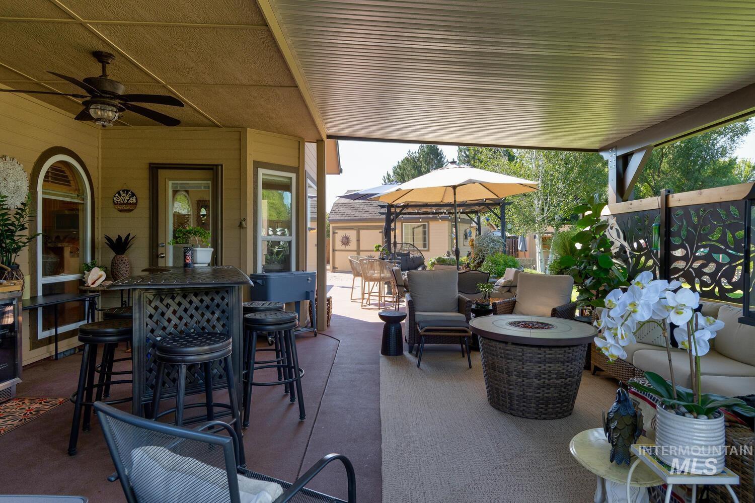 10585 West Vega Court Star, ID 83669 - Photo 32 of 49 View of patio / terrace with outdoor dining area, a ceiling fan, and an outdoor fire pit