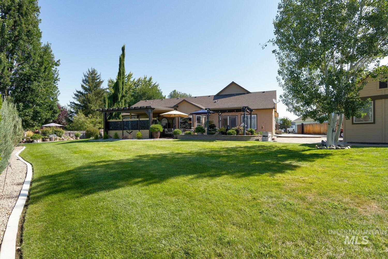 10585 West Vega Court Star, ID 83669 - Photo 42 of 49 Rear view of property with a lawn and a patio area