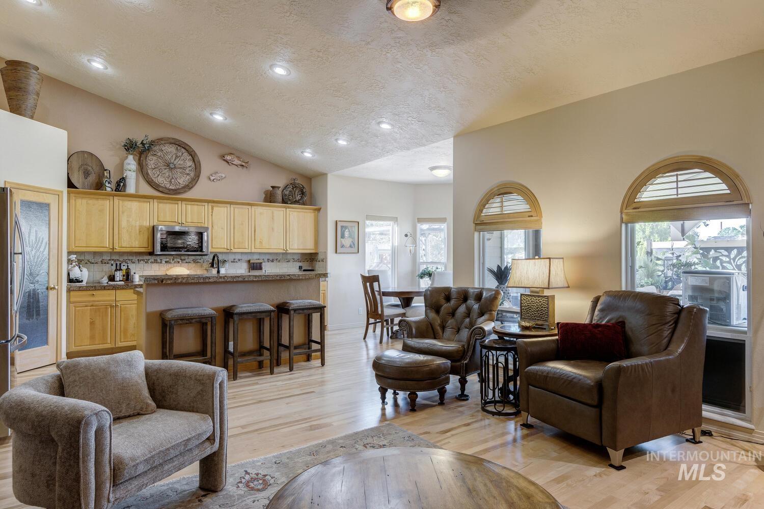 10585 West Vega Court Star, ID 83669 - Photo 6 of 49 Living area featuring vaulted ceiling, a textured ceiling, light wood-type flooring, and recessed lighting