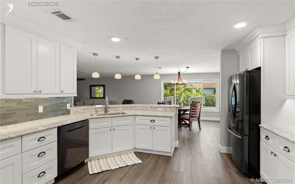 5321 Southeast Sterling Circle Stuart, FL 34997 - Photo 11 of 29 a kitchen with white cabinets and stainless steel appliances