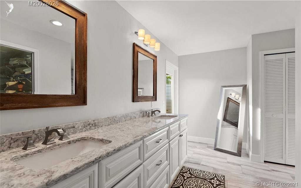 5321 Southeast Sterling Circle Stuart, FL 34997 - Photo 16 of 29 a bathroom with a granite countertop double vanity sink and a mirror