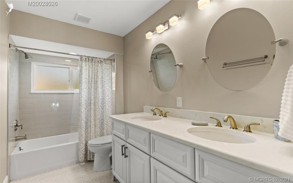 5321 Southeast Sterling Circle Stuart, FL 34997 - Photo 19 of 29 a bathroom with a sink a toilet and a mirror