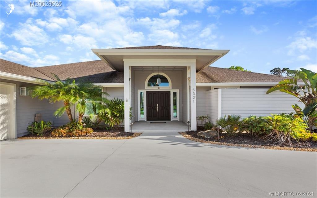 5321 Southeast Sterling Circle Stuart, FL 34997 - Photo 3 of 29 a front view of a house with garden