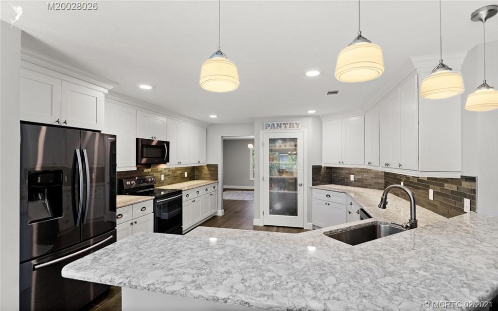 5321 Southeast Sterling Circle Stuart, FL 34997 - Photo 9 of 29 a kitchen with stainless steel appliances granite countertop a sink refrigerator and microwave