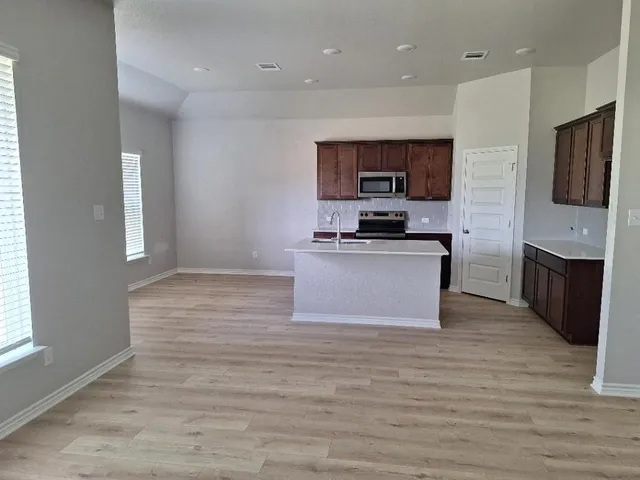 a kitchen with stainless steel appliances granite countertop a stove top oven a sink dishwasher a refrigerator and a oven