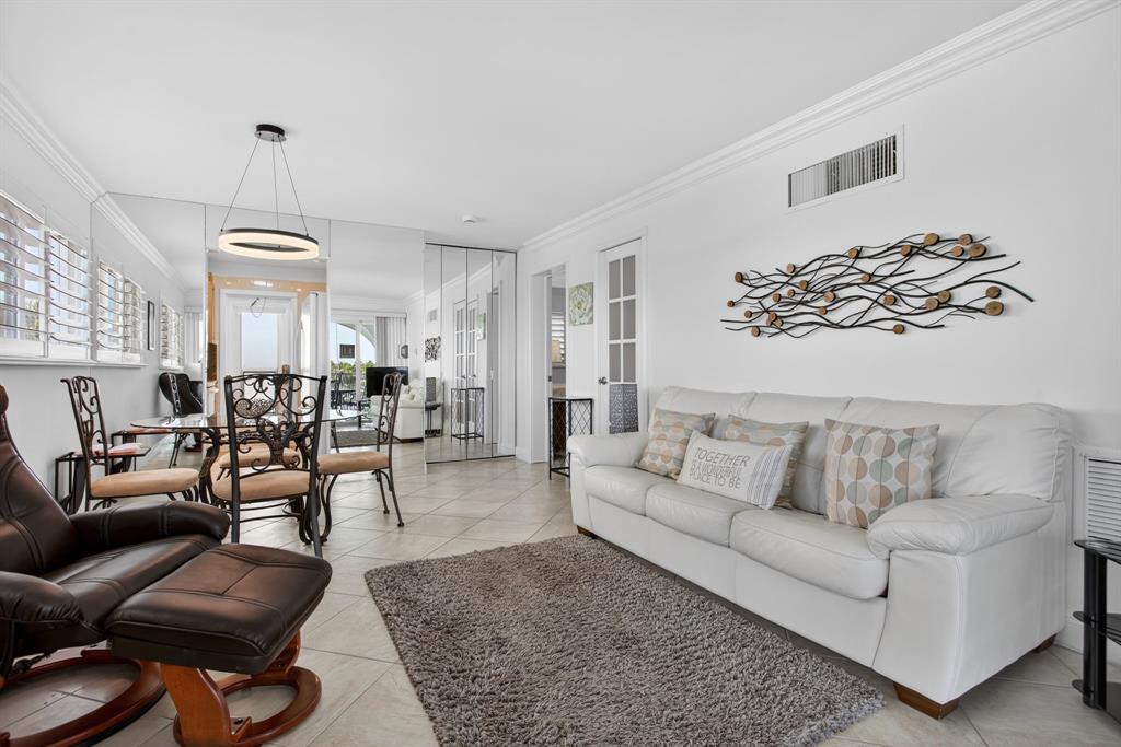 505 North Riverside Drive, Unit 21 Pompano Beach, FL 33062 - Photo 7 of 24 a living room with furniture and a chandelier