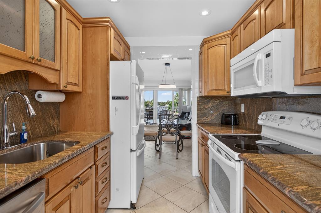505 North Riverside Drive, Unit 21 Pompano Beach, FL 33062 - Photo 9 of 24 a kitchen with granite countertop a sink a stove and refrigerator